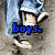 six shows a person in blue jeans and white sneakers on sandy ground, with colored text overlays changing across the