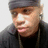 A person wearing a dark headband and black clothing with earphones, shown in three where the head turns slightly left to right
