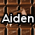 Pixelated image with brown wooden background and white text reading 'Aiden' in bold, blocky font with black outlines.
