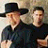 Two men in dark clothing with one wearing a black hat, next to pixelated text reading Montgomery Gentry on a beige background.