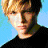 Pixelated image of a person with light brown hair wearing a black shirt against a blue background, next to text and a heart symbol on a black background.