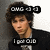Pixelated image of a person with dark curly hair wearing black clothing, two text banners above and below the head.