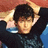 Pixelated image of a person with dark hair wearing black clothing, hands behind head against red and blue background with text 'zoc is sexy' on cyan side.