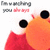 A cartoon character with large black eyes and an orange face, wearing a red outfit, appears in four with text above it