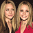 Two identical women with long blonde hair and red tops appear side-by-side on a blue background with green pixelated text.