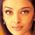 Pixelated close-up of a person's face with warm orange and brown tones, showing eyes, eyebrows, nose, and mouth in a static composition.