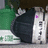 Pixelated static image shows a dark figure with white accents against green and gray background elements.