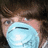A person wearing a light blue surgical mask with visible eye and hair details, alongside repeated 'SEIZURE' text in white on black backgrounds.