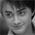 Grayscale pixelated portrait of a person with short dark hair, neutral expression, and visible facial features including eyebrows, eyes, nose, and mouth.