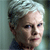 Pixelated close-up of a person with short light-colored hair, neutral expression, and visible ear against a muted background.