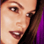 Pixelated close-up of a person's face showing eyes, nose, mouth, and hair with visible purple and black background elements.
