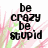 Pixelated text on a pink and green striped background with a gray rectangle in the bottom right corner.