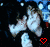 Pixelated character with dark hair and light clothing, hands near face in a gesture, red heart on left side of frame.