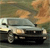 Pixelated image of a light-colored sedan with dark trim, positioned on a road under a gradient sky with orange and green tones.