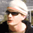 Static 48x48 pixel icon showing a person wearing sunglasses and a white beanie, with visible facial features including nose, lips, and ear, against a blurred background.