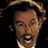 Pixelated static image of a man's face with dark hair and light skin, wearing a white shirt collar against black background.