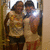 Two people in casual clothing stand close together, one holding a bright light source near their faces.