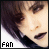 A pixelated close-up of a person with dark hair and heavy eye makeup, showing text "FAN" in the bottom-left corner.