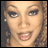 Pixelated close-up of a person's face with light skin tone, brown eyes, and open mouth showing teeth against blurred background.