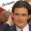 A pixelated close-up of a person in a dark suit with a white shirt and black tie, holding a phone to their ear, with another person partially visible in the background and the word 'Orlando' in black handwritten text above.
