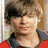 A pixelated image of a person with light brown hair wearing a red top and dark collar, shown in two side-by-side views with different backgrounds.