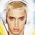Pixelated close-up of a person with light brown hair, blue eyes, and a neutral expression against a bright background with yellow and blue elements.