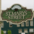 Green and brown sign with 'St Marys Street' text, white cloud above, dark blue background with small square elements.
