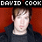 Pixelated image of a person with light skin and brown hair against red background, topped by white blocky text reading DAVID COOK.