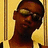 A pixelated image of a person with dark skin wearing sunglasses and a white shirt, with red text overlaid on the right side.