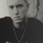 Static 48x48 pixel icon showing a grayscale close-up of a person's face with dark clothing and necklace, rendered in low-resolution pixel art style.