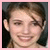 Pixelated close-up of a person with light skin, brown hair, and closed eyes smiling broadly against a dark background framed by pink border.