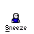 Pixelated character in blue shirt with white face and black outline, showing sneezing animation with green particle effects under gray background.