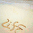 A pixelated image with a light beige background and a stylized brown symbol resembling a cursive 'C' or 'G' in the lower-left corner.