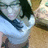 Pixelated static image shows a figure in light blue clothing with dark hair against a blurred background of brown and light blue tones.