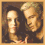 Four- shows a woman with long dark hair and light skin, a man with short gray hair and light skin, and their hands clasped together in warm lighting