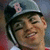 A pixelated close-up of a person wearing a dark cap with light-colored brim and a visible number '8' on the side, set against a blurred background.