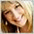 A pixelated portrait of a smiling person with light brown hair appears on the left side of a solid blue background, accompanied by yellow text reading "JUSTNA IS COOL".