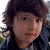 A young person with brown curly hair and a dark jacket appears in three showing slight head movement