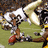 Pixelated image of a football player in white uniform holding a red ball on a green field with a black background containing yellow text.