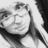 Pixelated grayscale image of a person with dark hair and light clothing, partially cropped on the right side.