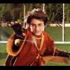 A static image featuring a character in red and gold robes holding a wand, with text elements on black background.
