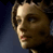 Pixelated close-up of a person's face with brown hair and light skin, set against a dark blue background.