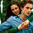 Two people in a close embrace, one wearing a light blue shirt, against a green background with a white vertical stripe on the left.