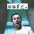 Pixelated static image shows a person with dark hair and beard wearing light blue shirt against teal background, topped by white banner with four small icons.