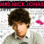 Pixelated image of a person with dark curly hair wearing a light-colored shirt, set against a white background with scattered colored pixels and red text at the top.