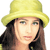 Pixelated static image of a person wearing a yellow hat with long dark hair and light skin tone against white background.