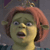 Pixelated close-up of a green-skinned character with short reddish-brown hair, wide eyes, and an open mouth against a dark background.