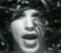 A black-and-white pixelated image of a person with dark hair and an open mouth, transitioning to the same face overlaid with yellow text reading "SOUL TO ESQUEEZE".