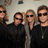 Four people in dark clothing pose together under a ceiling fixture, with text reading "BON JOVI" and "FOREVER AND EVER!!!!!" on adjacent