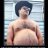 Static pixelated image of a shirtless person with dark hair against a light striped background.